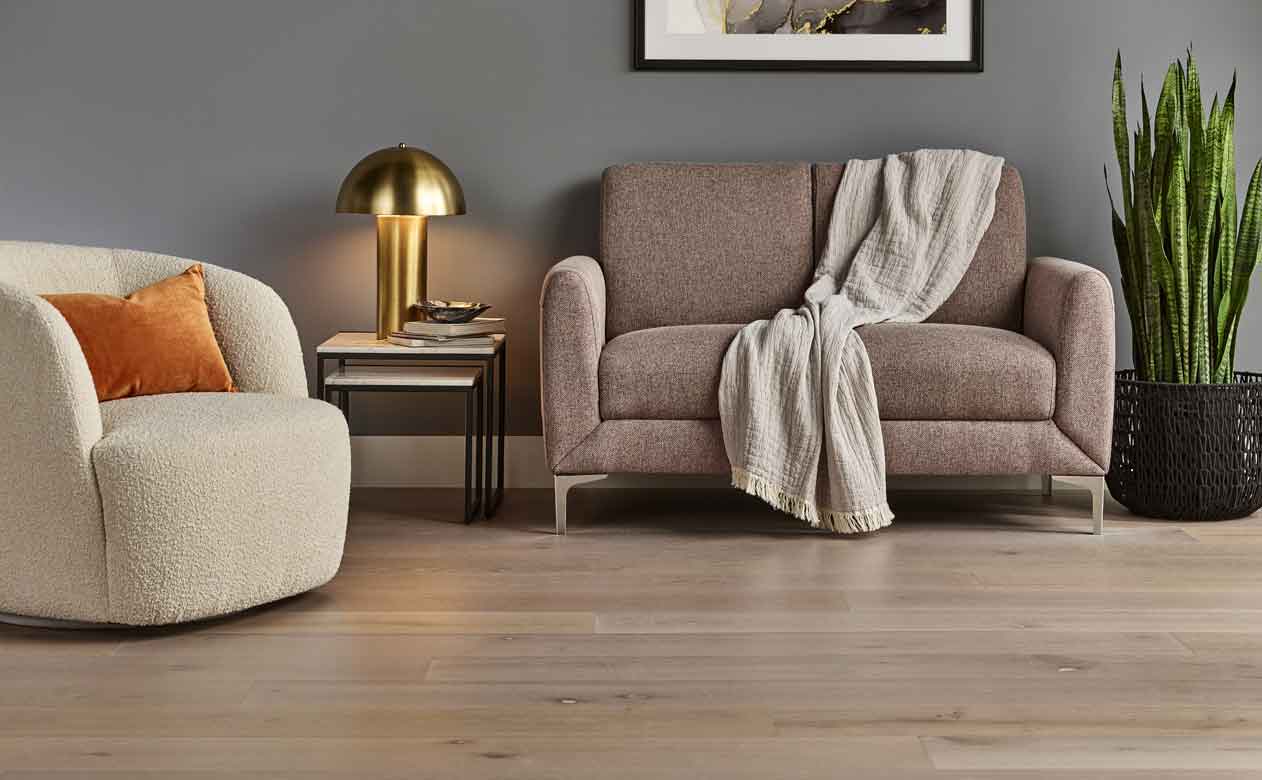 light hardwood flooring in gray living room with plush furniture
