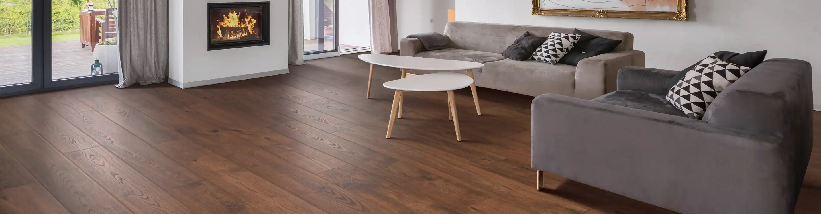 wood look laminate flooring in living room with grey couches